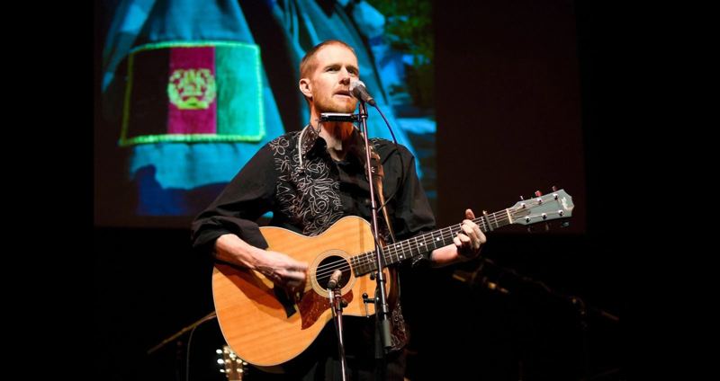 Fred Smith singing with guitar and harmonica